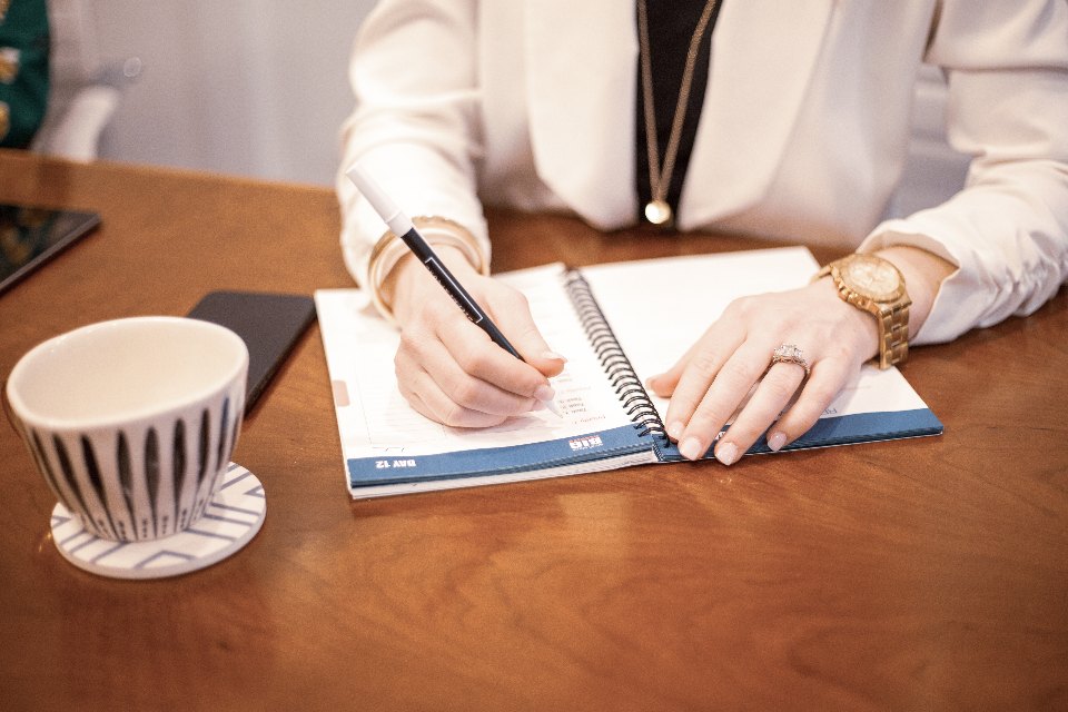 Writing a reflection in a notebook